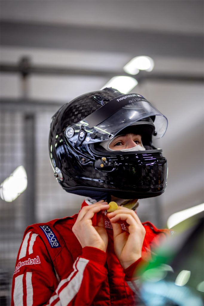 Rennfahrerin zieht Helm an